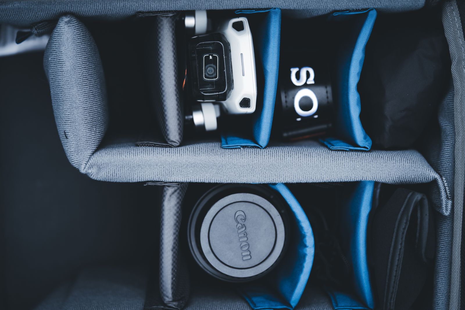 Equipo fotográfico en los compartimentos de una mochila